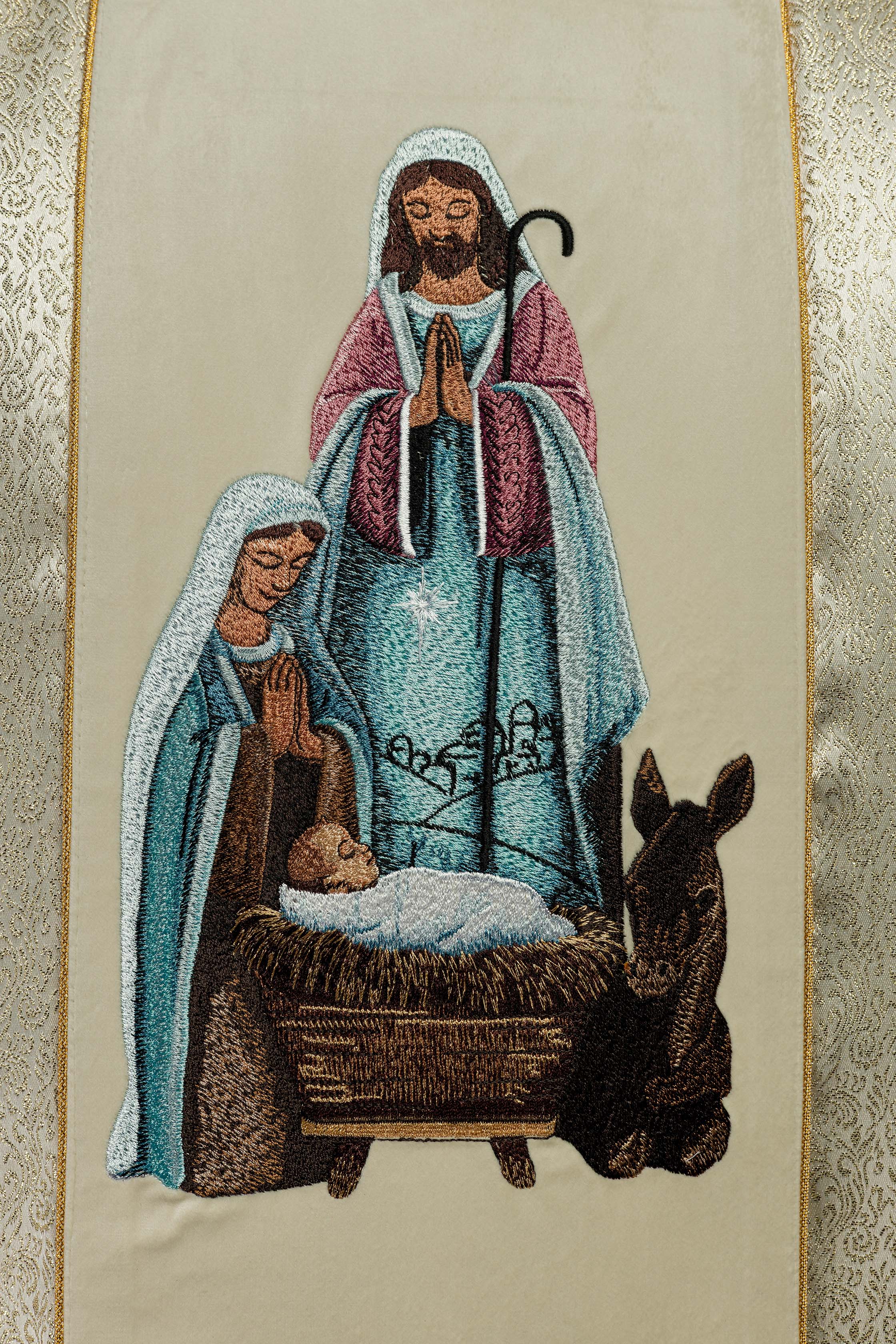 Casula bordada com a imagem da Sagrada Família sobre tecido dourado