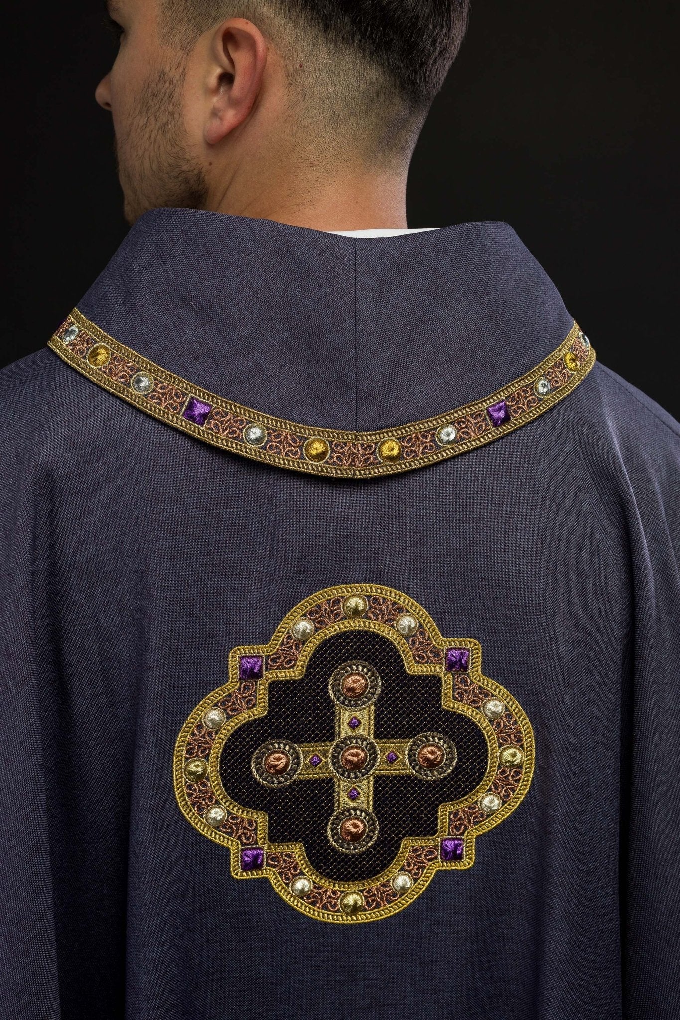 Casulla de color morado con ribetes bordados en el cuello y alrededor del bordado de la cruz. S - 7066 - 03 - 70 - CASULLAS.ES