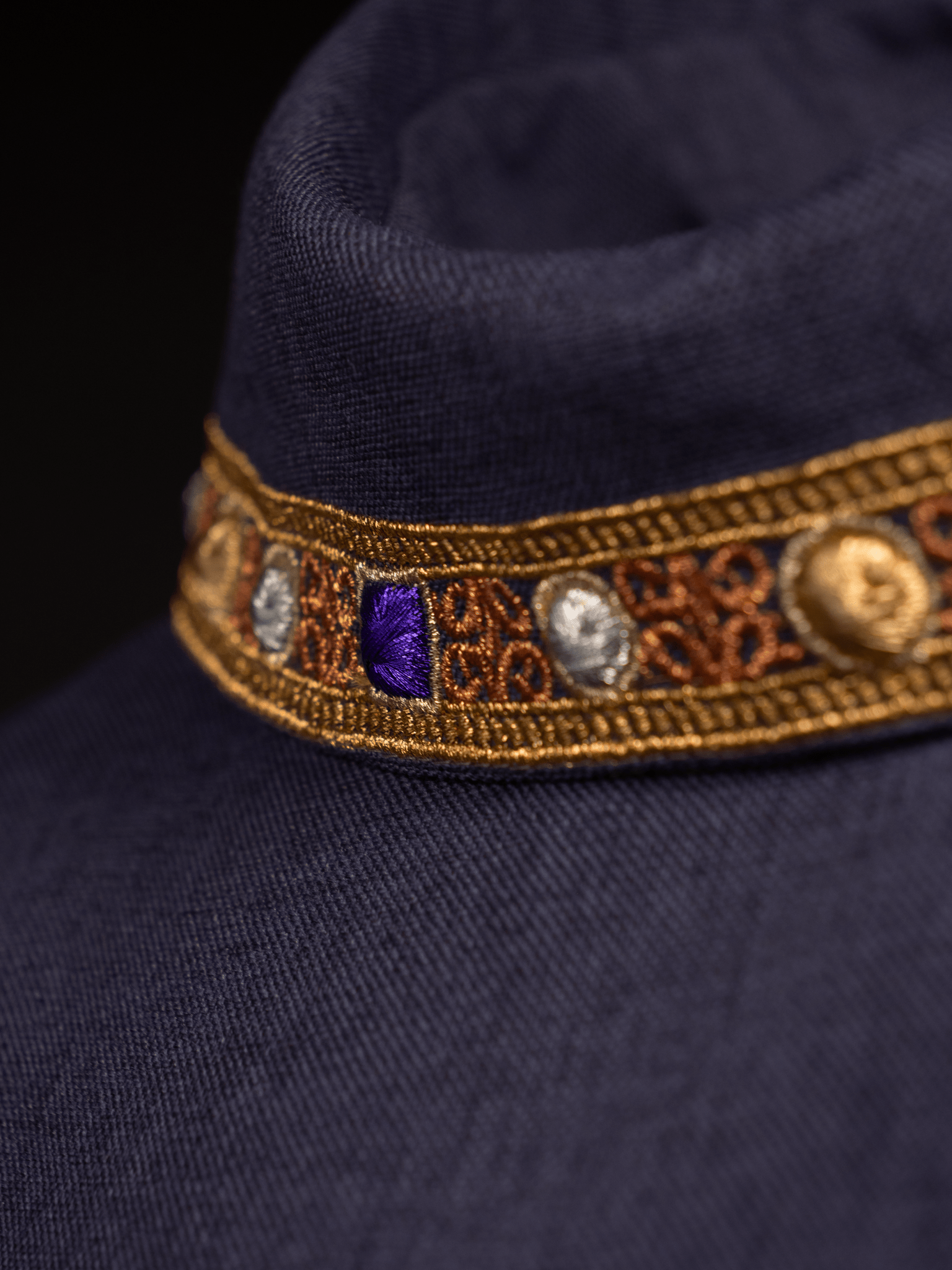 Casulla de color morado con ribetes bordados en el cuello y alrededor del bordado de la cruz. S - 7066 - 03 - 70 - CASULLAS.ES