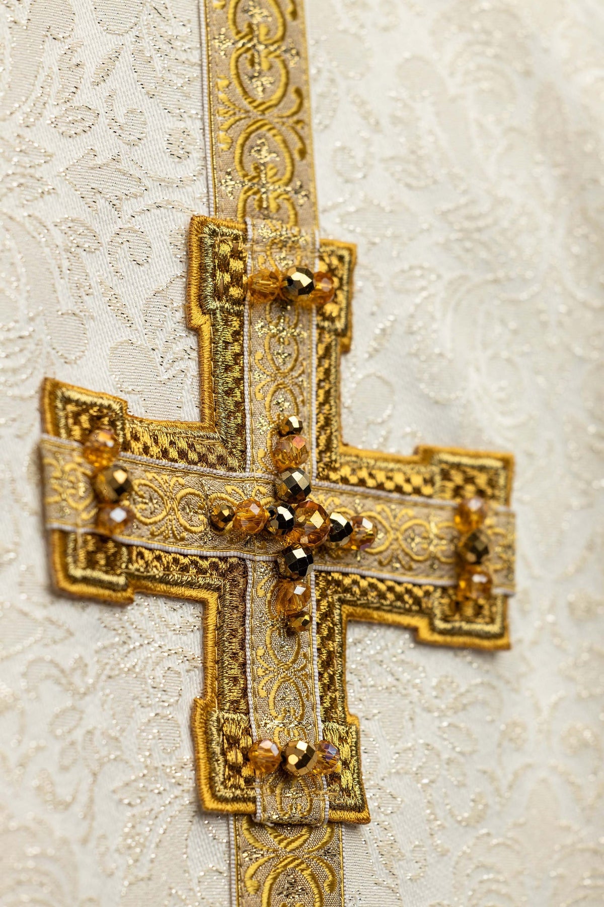 Casulla Handmade 7007 con piedras naturales, detalle frontal de cruz bordada en dorado sobre tejido marfil