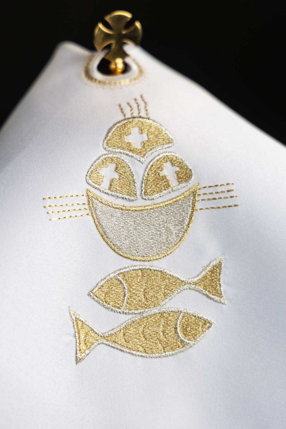 Cubrecopón con bordado dorado, detalle frontal de pan y dos peces