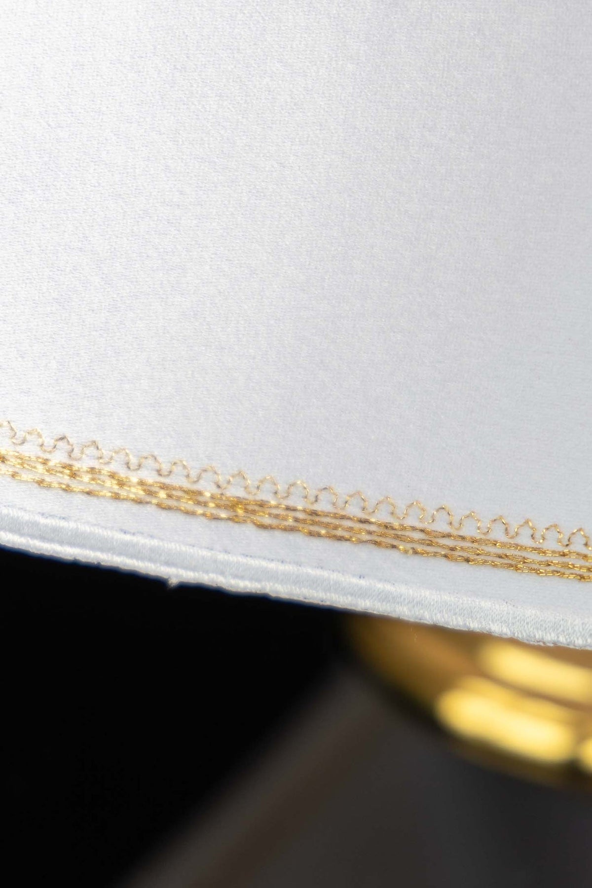 Cubrecopón blanco, detalle del bordado dorado del borde