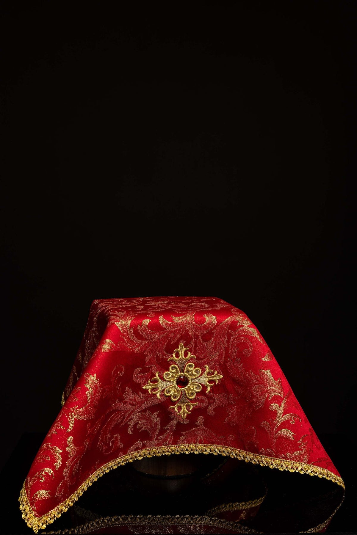 Velo de cáliz rojo con cruz bordada y piedra decorativa roja, vista frontal con ribete dorado