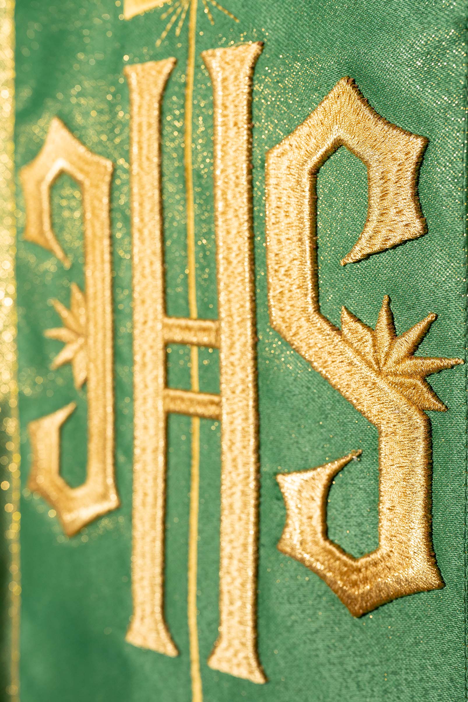 Casula verde ricamente decorada com motivo dourado e faixa larga com símbolo IHS