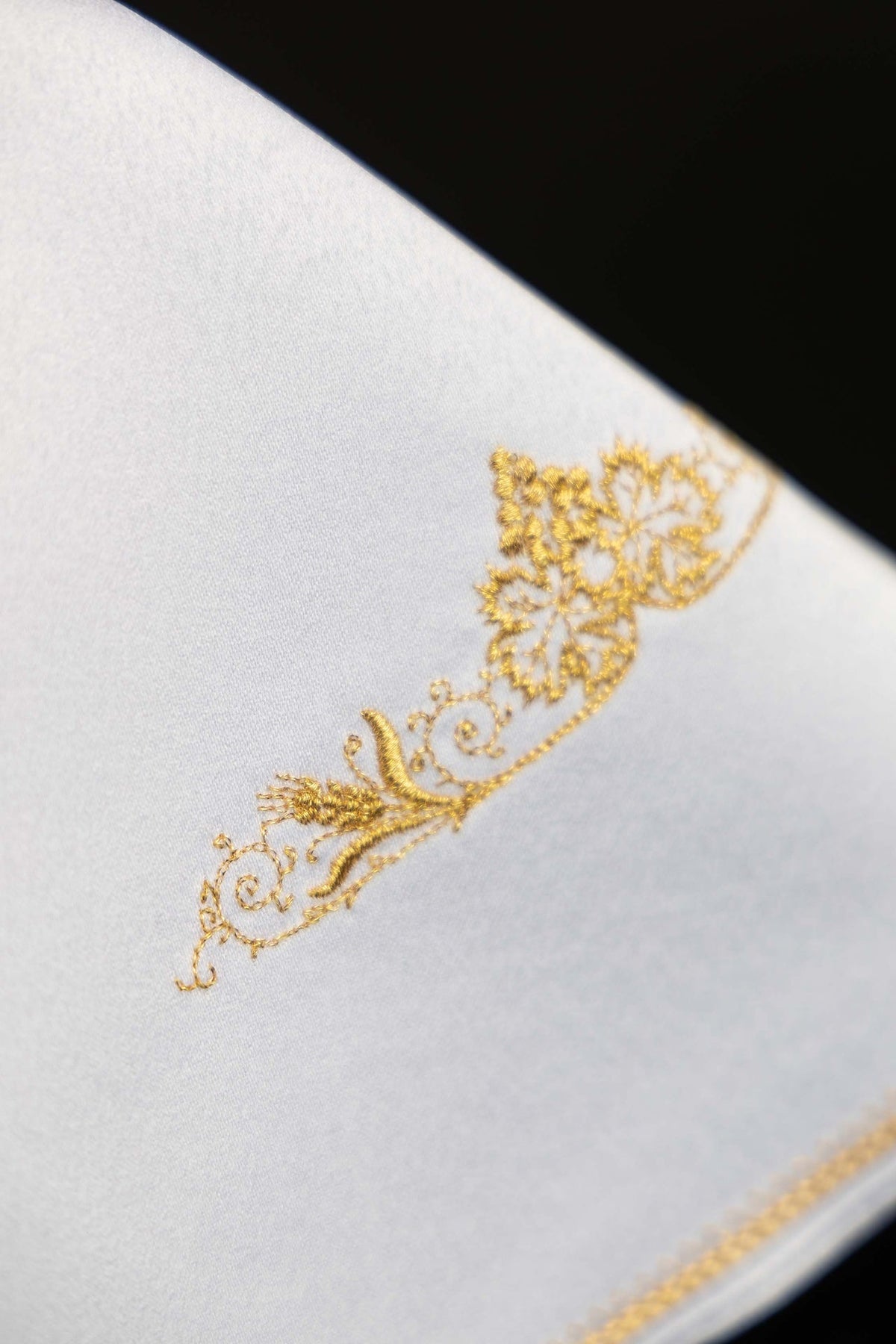 Cubrecopón blanco, detalle del bordado floral dorado lateral